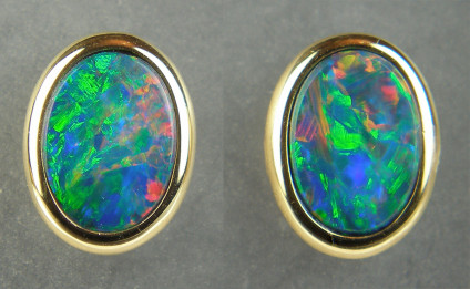 Opal doublet earstuds in 18ct yellow gold - Vibrant multicoloured opal doublet oval pair weighing 1.32ct, rubover set in 18ct yellow gold. Earstuds are 7x9mm