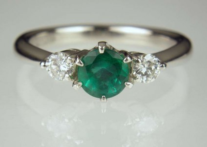 Emerald & Diamond Ring - 0.65ct emerald round set with a matched pair of 0.20ct round brilliant cut diamonds in platinum