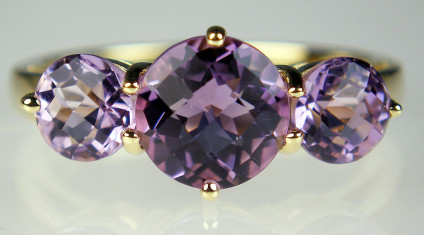 Amethyst three stone ring in 9ct yellow gold - Three round chequerboard (also known as harlequin cut) amethysts set in a 9ct yellow gold ring