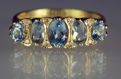 Aquamarine & diamond ring in 18ct yellow gold - Pretty secondhand ring made in an antique style gypsy setting in 18ct yellow gold set with 5 oval aquamarines totalling approximately 2ct and set with 8 x little 16 cut round diamonds totalling about 0.1ct diamond weight. The ring is size O 1/2, and is in excellent condition.
