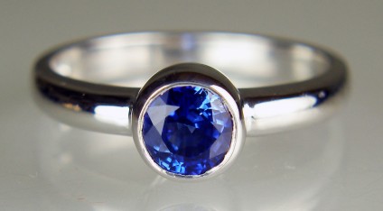 Sapphire ring in 18ct white gold - 6.1mm round  bright blue sapphire weighing 1.34ct rubover set in 18ct white gold ring