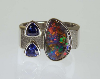 Boulder opal & sapphire ring in palladium - 2.36ct boulder opal from Queensland, set with a 0.65ct pair of trillion cut sapphires, in a polished and frosted palladium ring