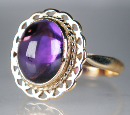 Amethyst cabochon ring in 9ct yellow gold - 11 x 9mm oval cabochon amethyst weighin 4.36ct set in ornate 9ct yellow gold ring. Ring is size P and can be resized.