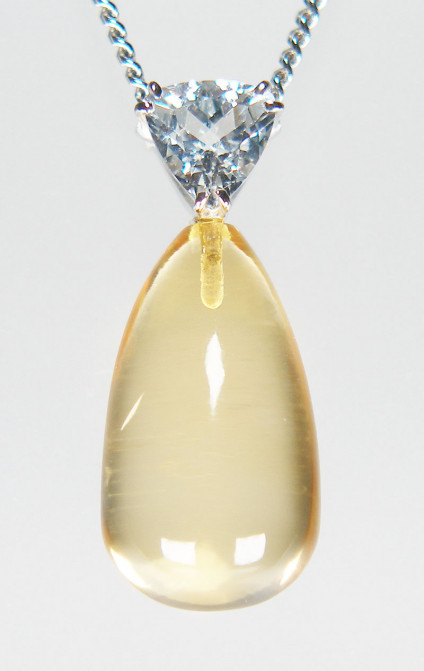 Cirtine & goshenite pendant in 9ct white gold - 10x18mm polished drop shaped citrine suspended from a 0.70ct trillion cut goshenite (colourless beryl), on an 20" curb link chain, all in 9ct white gold. The pendant is 27mm long. This pendant and chain is included in our 20th anniversary 50% sale and now costs £295.