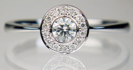 0.30ct diamond rubover halo ring in 18ct white gold - 0.20ct central round brilliant cut diamonds in G colour VS clarity, surrounded by a halo of matching smaller diamonds, total diamond weight 0.30ct, in 18ct white gold