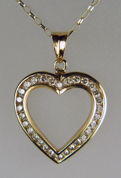 1ct diamond heart pendant in 9ct yellow gold - 1ct of round brilliant cut diamonds channel set into a pretty heart shaped pendant and suspended from an 18" 9ct yellow gold chain. Diamonds are I/J colour and VS clarity. Pendant measures 24mm wide by 34mm long. The piece is secondhand but in 'as new' condition.