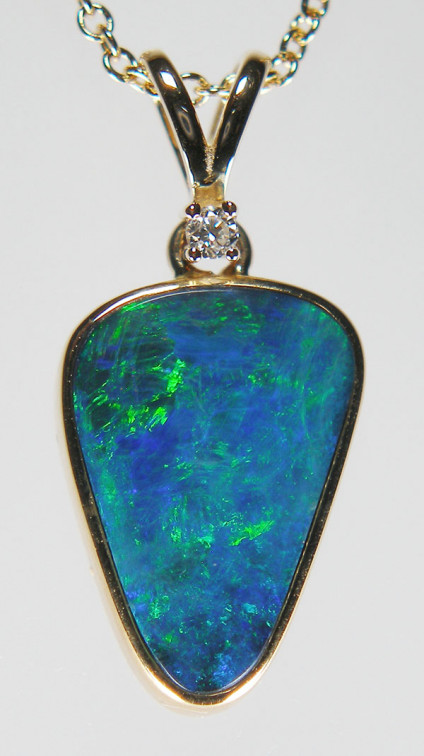 Doublet opal & diamond pendant in 9ct yellow gold - Inverted triangular shaped bright blue nd green doublet opal rubover set and suspended from a small round brilliant cut diamond, all mounted in 9ct yellow gold pendant. Pendant is 23mm long. The chain is available for separate purchase.