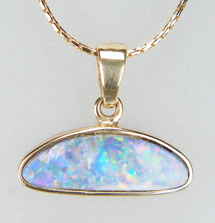 Opal doublet pendant in 9ct yellow gold - Sparkly blue red and green doublet opal rubover set in 9ct yellow gold pendant. Pendant measures 18 x 15mm. Price excludes chain.