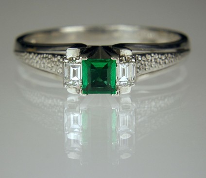Emerald & diamond ring in platinum - Emerald & diamond ring in platinum. 10pt Colombian emerald flaked by 2 x 5pt baguette cut diamonds. Head 7 x 4mm.
