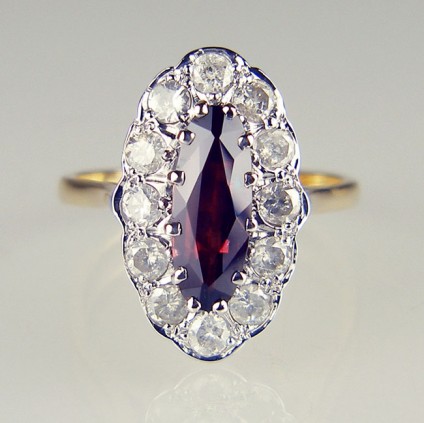 Marquise cut garnet and diamond cluster ring - Marquise cut brownish red pyrope garnet surrounded by 1ct of round brilliant cut diamonds. The diamonds are white but quite heavily included with white inclusions. We estimate the grade to be E/F colour I1 clarity. The ring is secondhand but in excellent condition and UK hallmarked in 18ct yellow and white gold.  The ring shank being yellow gold. Ring size R1/2.
