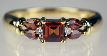 Garnet & diamond ring in 9ct yellow gold - Garnet round and marquise cuts weighing 0.73ct and set with 2 points of round brilliant cut diamonds, mounted in 9ct yellow gold. A very lovely ring.