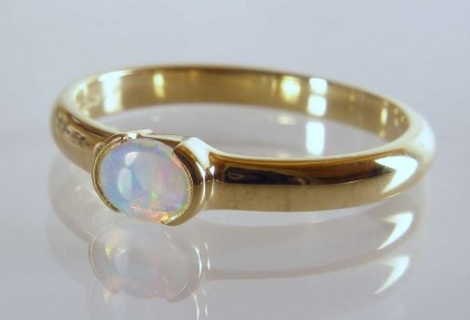 Opal Ring - 0.18ct white opal with vivid green and blue colour flashes set in 18ct yellow gold