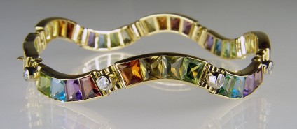 Gemset bracelet in 18ct white & yellow gold - 17.72ct of wedge cut coloured gemstones, set with 1.23ct diamonds in 18ct yellow and white gold. A stunning and unique bracelet. Coloured gemstones are peridot, citrine, garnet, tourmaline, amethyst and blue topaz.