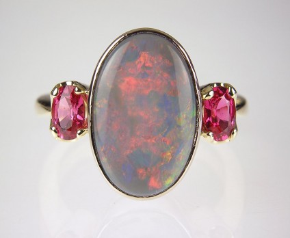 Black opal & Mahenge spinel ring in gold - Opal & red spinel ring - Ring set with 3.4ct oval black opal and a pair of oval cut Mehenge spinels in 18ct yellow gold.