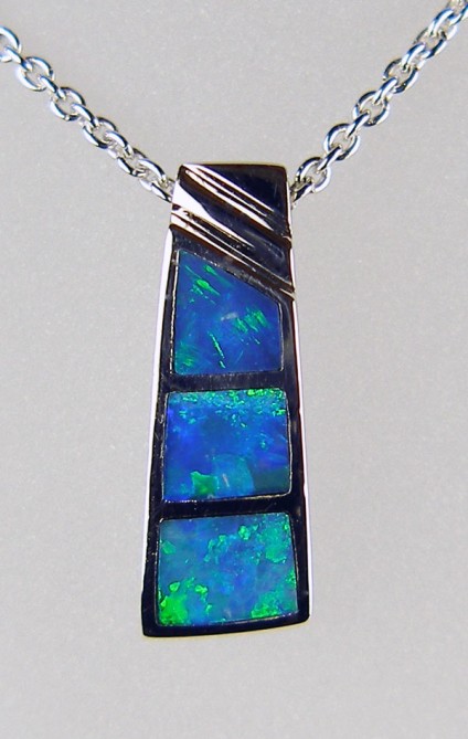 Inlaid black opal pendant in silver - Pretty silver pendant inlaid with Australian solid black opal. The pendant has been rhodium plated to resist tarnishing and is suspended from a rhodium plated silver chain of adjustable length 15-22".