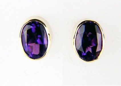 Oval amethyst earstuds in yellow gold - 7.2 x 5.5mm oval cut amethysts in a lovely deep purple with bluish colour flashes, rubover set in 9ct yellow gold