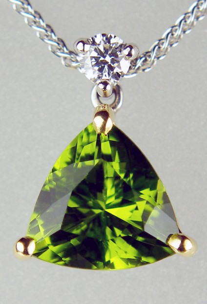 Peridot & diamond pendant in 18ct white & yellow gold - 2.62ct trillion cut green peridot set with a 0.10ct round brilliant cut white diamond G/VS in 18ct yellow and white gold suspended from a delicate spiga chain in 18ct white gold