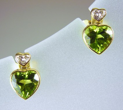 Peridot & diamond earrings in 18ct gold - Peridot & diamond heart earrings in 18ct yellow gold. 2.53ct peridot and 0.19ct diamond heart shaped pairs, bezel set as stud earrings 7 x 11mm.
