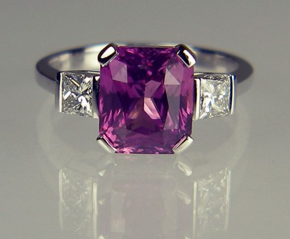 Pink Sapphire & Diamond Ring - 3.62ct pink sapphire set with a 0.46ct pair of princess cut diamonds in F colour SI clarity in 18ct white gold