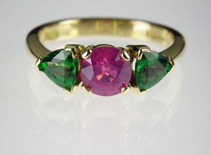 Pink sapphire & tsavorite ring - Vivid pink sapphire 1.17ct flanked by a 0.97ct pair of tsavorite garnet pear cuts in 18ct yellow gold. Centre stone 6mm diameter.
