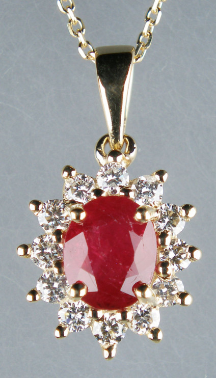 Ruby & diamond cluster pendant in 9ct yellow gold - Oval ruby - included natural heat treated but NOT glass filled - weighing 0.86ct, surrounded by a halo of 0.27ct round brilliant cut diamonds, mounted in 9ct yellow gold and suspended from a 16-18" fine trace chain in 9ct yellow gold. The chain is available for separate purchase £120. The pendant measures 10 x 17mm.