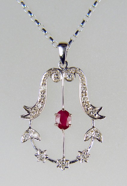 Ruby & diamond pendant in 9ct white gold - 0.5ct oval faceted ruby set with 0.2ct diamonds in 18ct white gold pendant. The piece is secondhand, measures 32mm long by 22mm wide and is in excellent condition. It is suspended from a 20" 9ct white gold chain.