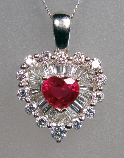 Ruby & diamond pendant in 18ct white gold - Truly captivating and romantic ruby pendant set with a 0.68ct heart cut natural ruby surrounded by a 0.70ct double halo of tapered baguette and round brilliant cut diamonds, suspended from an 18" fine curb chain in 18ct white gold. Pendant measures 18mm long and 12mm wide.