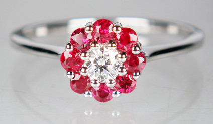 Ruby & diamond ring in 18ct white gold - Flower like cluster ruby and diamond ring with a central 0.17ct round brilliant cut diamond surrounded by a halo of 0.44ct rubies set in an 18ct white gold ring. RIng is size N, and can be sized. This ring is included in our 20 year anniversary sale and now costs £422.50.