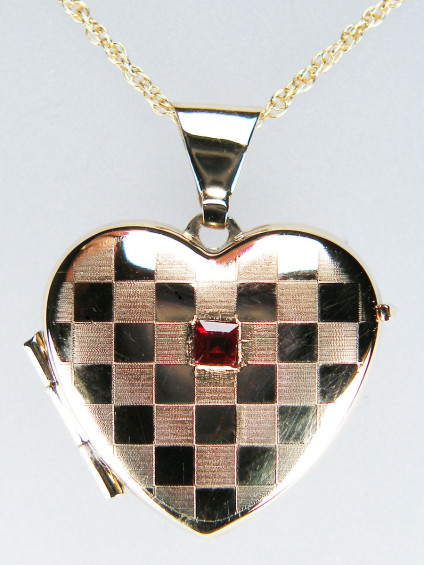 Ruby locket in 9ct yellow gold - Pretty chequerboard etched gold locket in 9ct yellow gold set with a 2mm square ruby suspended from a 16" 9ct yellow gold chain. Locket £110, chain £85, other lengths of chain available. Locket 16 x 22mm.