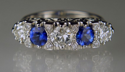 Engraved sapphire & diamond ring in platinum - 1.09ct of old cut round diamonds taken from a customer's remodelled 3 stone ring and reset with a further 0.06ct of tiny round brilliant cut diamonds and a 0.78ct round cut bright blue sapphire pair mounted in a handmade platinum engraved mount to replicate the popular late Victorian/early Edwardian setting style often seen in antique rings.