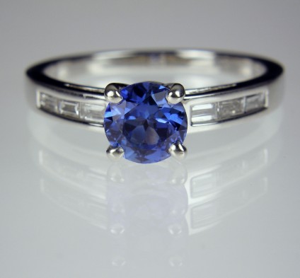 Sapphire & diamond ring in platinum - Round brilliant cut blue sapphire of lovely and intense periwinkle blue 0.9ct.  Set with 0.19ct baguette cut diamonds in platinum.
