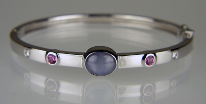 Star sapphire & diamond bangle - Elegant bangle in 18ct white gold set with a 4.36ct grey star sapphire set with 0.57ct of pink sapphires and 0.16ct of diamonds. This bangle was designed for the client, whose birthstone is sapphire, to wear daily and was a major birthday present to herself.  Just Gems has a wide selection of beautiful birthstone gems. We make many birthstone inspired pieces of special jewellery for our clients.