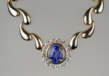 Tanzanite & diamond necklace in 18ct yellow gold - Exquisite tanzanite & diamond necklace with delicate drop shaped 18ct gold links. Central tanzanite measures 8.8 x 7.1mm and weighs 2.75ct, it si surrounded by a halo of 16 x 2.5mm round diamonds weighing 1ct. The necklace is 17.5" long.