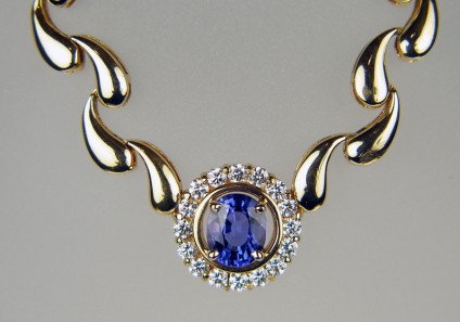 Tanzanite & diamond necklace in 18ct yellow gold - Exquisite tanzanite & diamond necklace with delicate drop shaped 18ct gold links. Central tanzanite measures 8.8 x 7.1mm and weighs 2.75ct, it si surrounded by a halo of 16 x 2.5mm round diamonds weighing 1ct. The necklace is 17.5" long. 