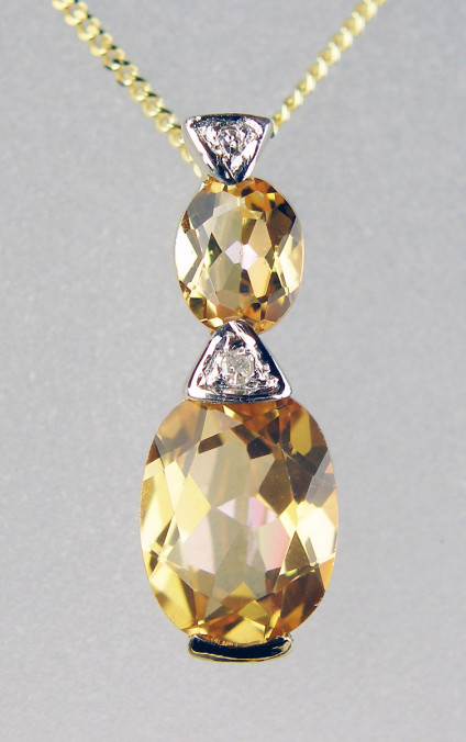 Topaz & diamond pendant in 9ct yellow gold - Delicate oval topaz and white diamond pendant set in 9ct yellow gold and suspended from an 18" 9ct yellow gold chain.Pendant is 16mm long