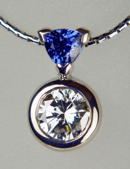 Diamond & sapphire pendant - 0.76ct round brilliant cut diamond in G colour SI1 clarity set with 0.31ct trillion cut sapphire in 18ct white gold