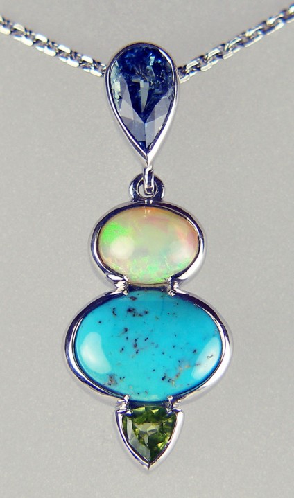 Aquamarine, turquoise, peridot, and opal birthstone pendant - Various gemstones (from the top - aquamarine, turquoise, opal and peridot) set in silver as a family birthstone (March, December, October, August) pendant