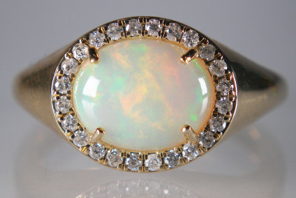 White opal & diamond ring in 9ct yellow gold - 1.99ct oval cabochon white opal surrounded by 0.19ct of round brilliant cut white diamonds in 9ct yellow gold