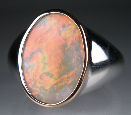 White opal ring in silver - Fiery orange/green flashing white opal rubover set in 9ct rose gold on silver ring. Ring is size O. Opal is 18 x 13mm.